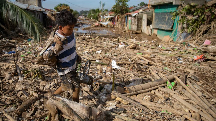 Boy & dog cross their destroyed village following Typhoon Vamco